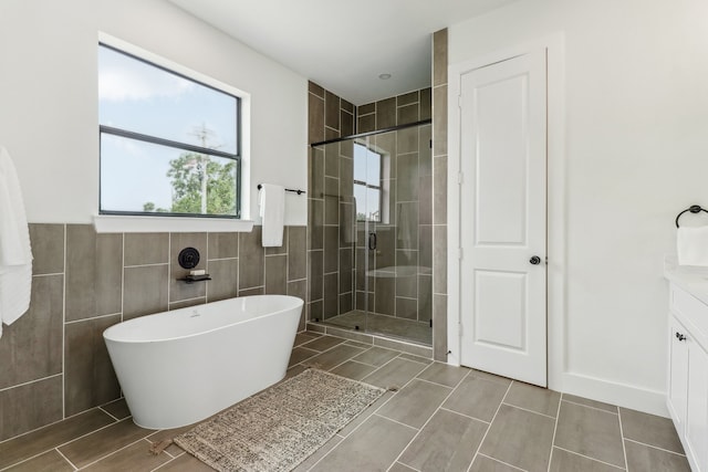 bathroom featuring tile patterned flooring, vanity, separate shower and tub, and tile walls