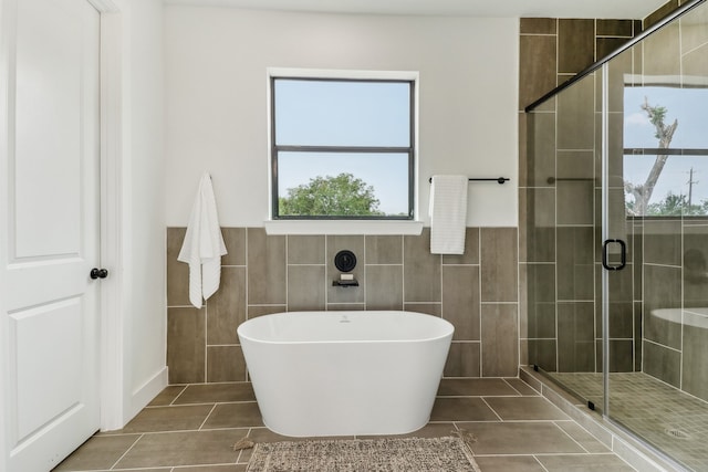 bathroom featuring tile walls, tile patterned floors, and separate shower and tub