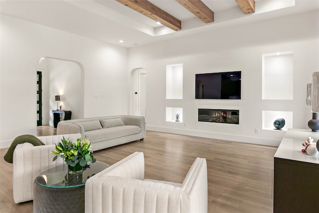 living room featuring beam ceiling and light hardwood / wood-style flooring