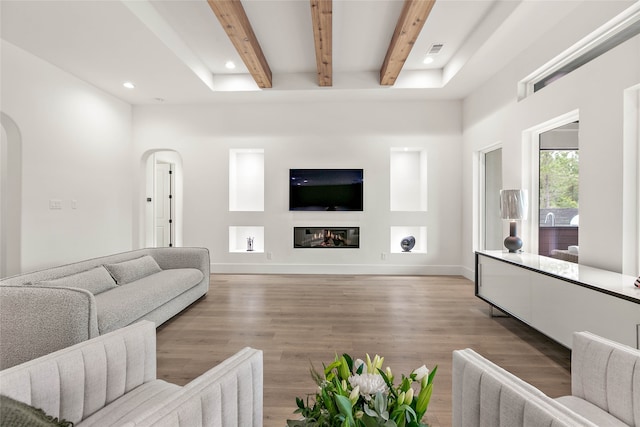 living room featuring beam ceiling and light wood-type flooring