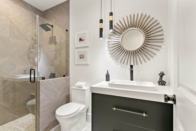 bathroom with a shower with door, vanity, and toilet