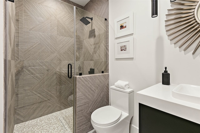 bathroom featuring toilet, vanity, and walk in shower