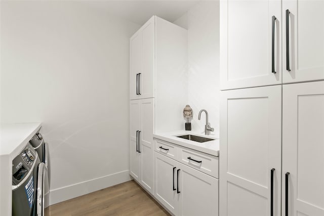 interior space with sink, white cabinets, and light hardwood / wood-style floors