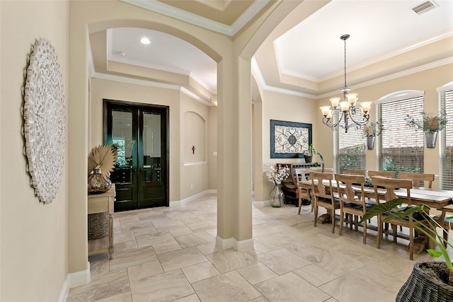 dining space featuring a tray ceiling, an inviting chandelier, and ornamental molding