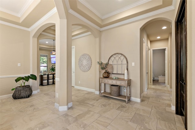 foyer featuring a raised ceiling and crown molding