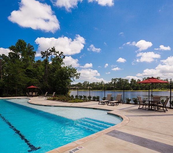 view of pool with a water view and a patio