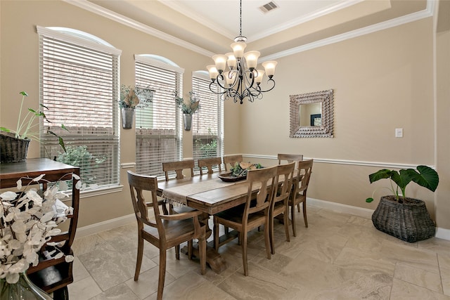 dining room with a chandelier, ornamental molding, and a tray ceiling