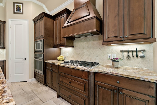 kitchen featuring tasteful backsplash, crown molding, stainless steel appliances, and custom range hood