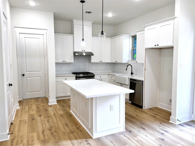 kitchen with white cabinetry, sink, appliances with stainless steel finishes, a kitchen island, and pendant lighting