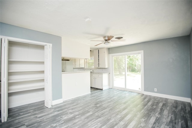 unfurnished living room featuring ceiling fan and dark hardwood / wood-style floors