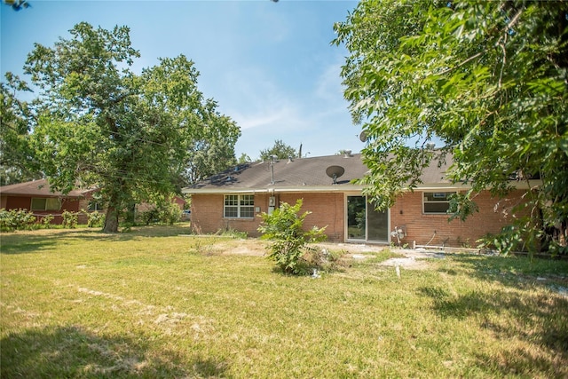 rear view of property featuring a lawn