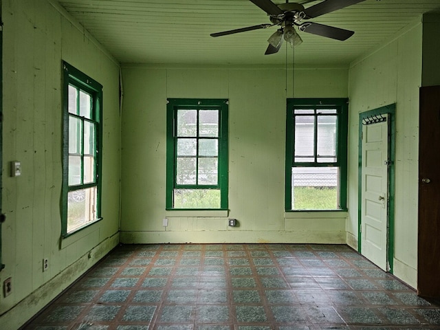 unfurnished room featuring ceiling fan and plenty of natural light