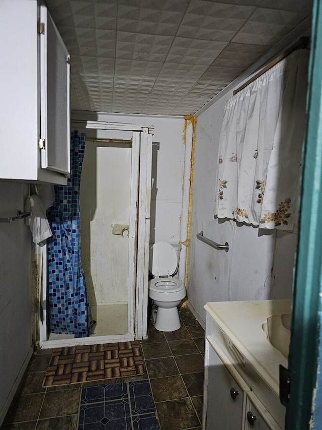 bathroom featuring tile patterned floors, walk in shower, a paneled ceiling, vanity, and toilet