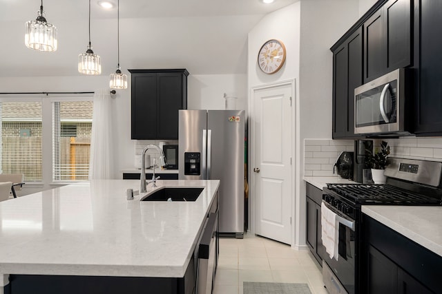 kitchen featuring a center island with sink, pendant lighting, light stone countertops, and appliances with stainless steel finishes