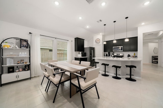 dining area with light tile patterned floors and lofted ceiling