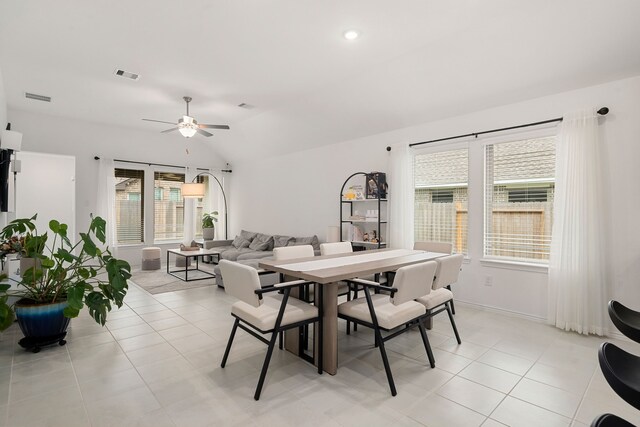 tiled dining space featuring ceiling fan and vaulted ceiling