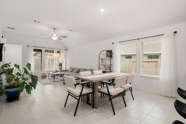 tiled dining room with lofted ceiling and ceiling fan