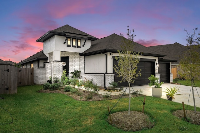 prairie-style home with a yard and a garage