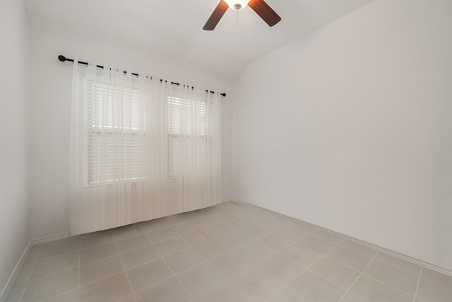 unfurnished room featuring ceiling fan, light tile patterned floors, and vaulted ceiling