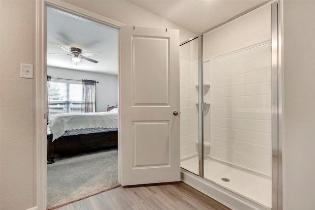 bathroom with walk in shower, wood-type flooring, and ceiling fan