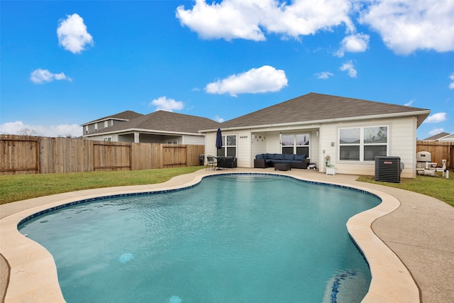 view of pool with cooling unit, a patio, and a yard