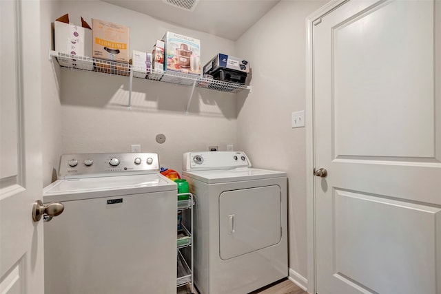 clothes washing area featuring light hardwood / wood-style flooring and washing machine and dryer