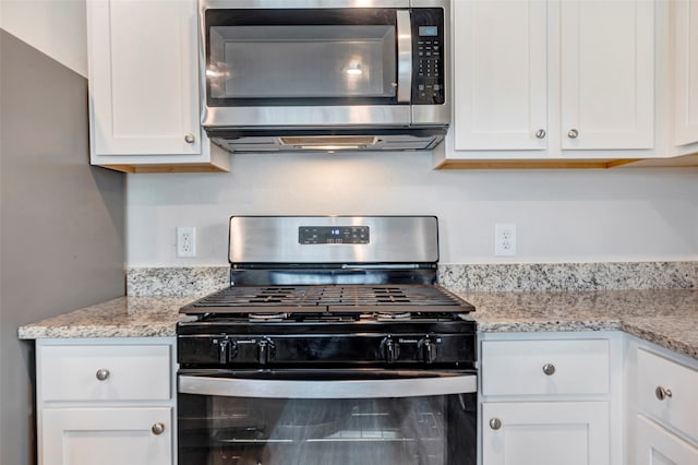 kitchen featuring white cabinetry, appliances with stainless steel finishes, and light stone counters