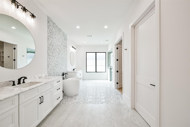 bathroom featuring a washtub and vanity