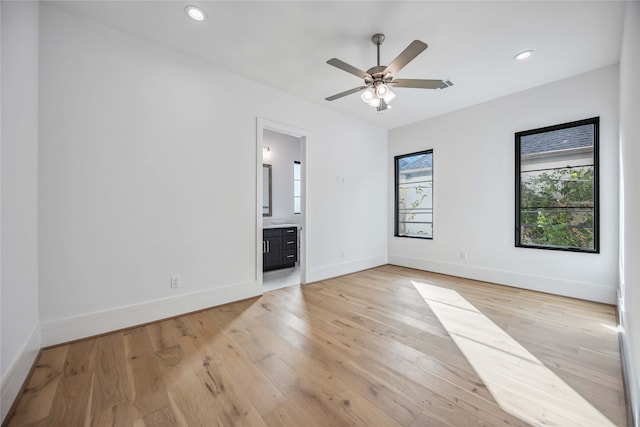 unfurnished bedroom with light wood-type flooring, ceiling fan, and connected bathroom