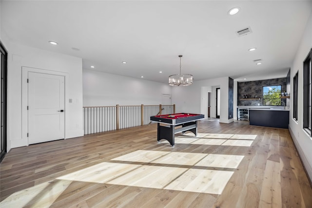 playroom with billiards, an inviting chandelier, and light hardwood / wood-style flooring