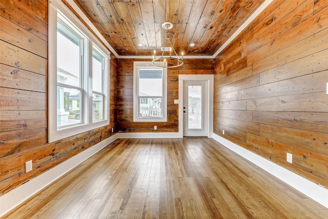 1324 Ursuline St, Galveston, TX 77550 - empty room with wood ceiling, a chandelier, wooden walls, wood-type flooring, and baseboards