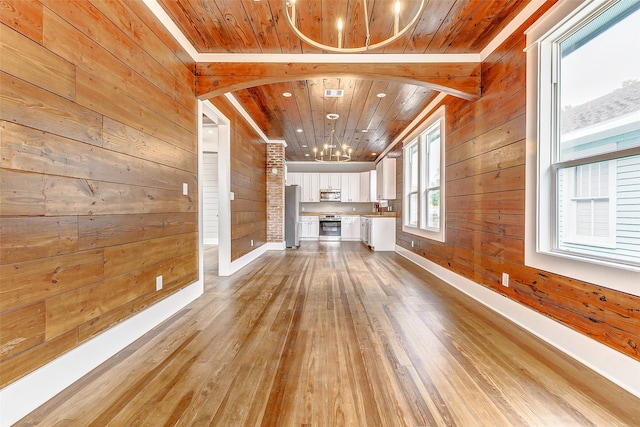 unfurnished living room with wood walls, wood ceiling, and light hardwood / wood-style flooring