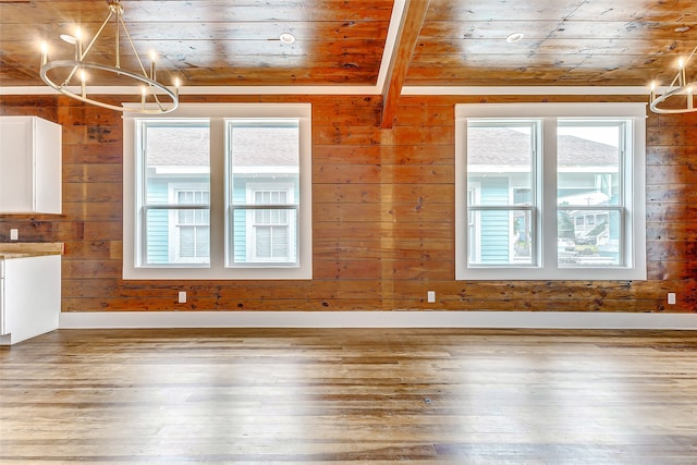 unfurnished living room featuring wooden ceiling, wood-type flooring, wooden walls, and a chandelier