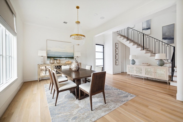 dining area featuring a chandelier, plenty of natural light, and wood-type flooring