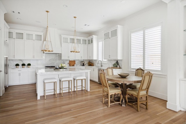 kitchen featuring light hardwood / wood-style flooring, white cabinetry, a kitchen island, and custom exhaust hood