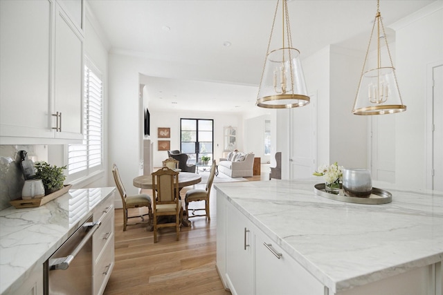 kitchen with pendant lighting, dishwasher, a center island, white cabinets, and light hardwood / wood-style floors