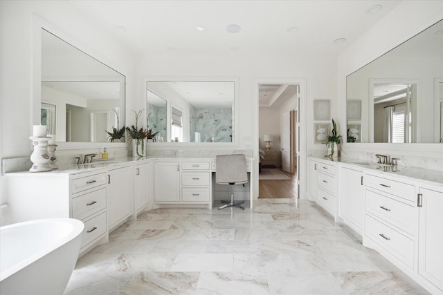 bathroom featuring a washtub and vanity