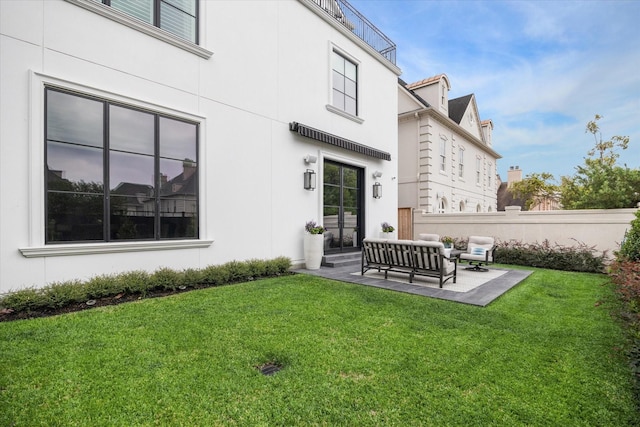 rear view of property with a yard, a patio, and an outdoor hangout area