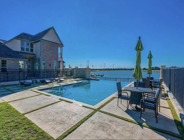 view of pool featuring a water view and a patio