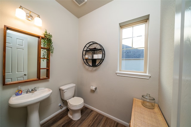 bathroom featuring wood-type flooring, toilet, and sink