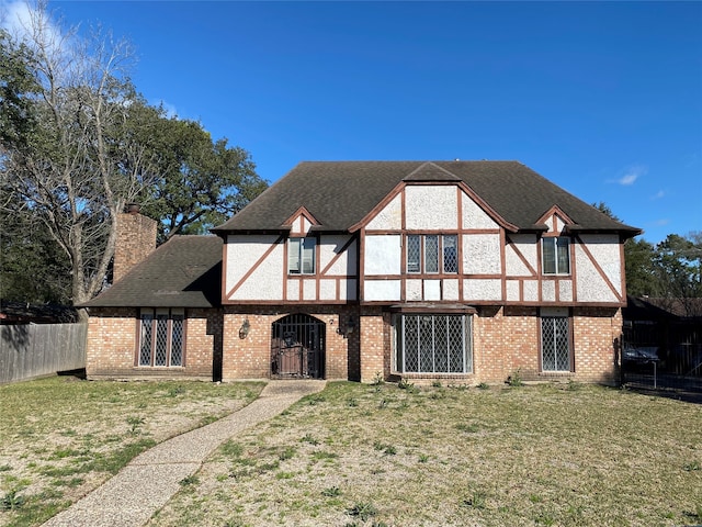 tudor-style house featuring a front yard