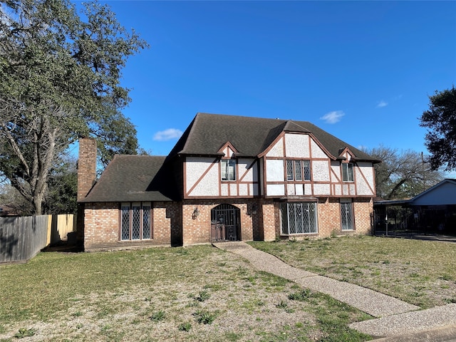 tudor home featuring a front lawn