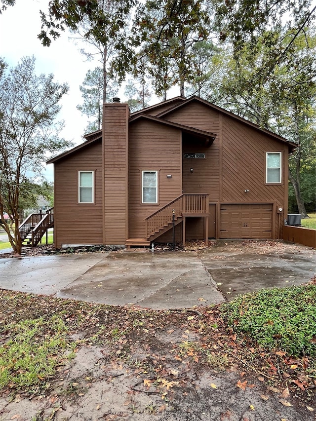 rear view of house featuring a garage and central AC unit