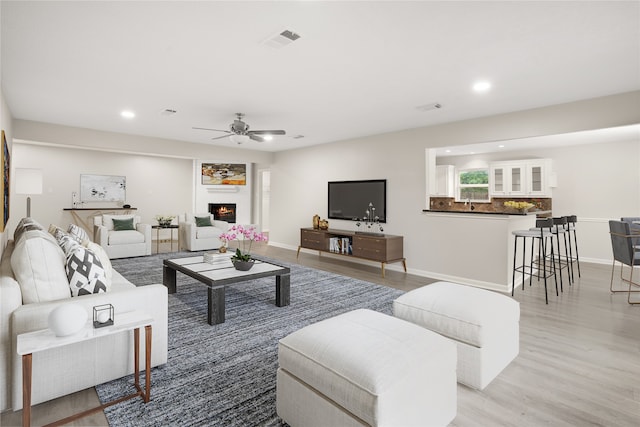 living room with ceiling fan and light hardwood / wood-style floors