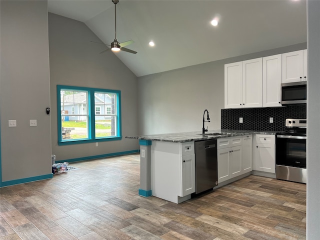 kitchen with stainless steel appliances, white cabinets, sink, and kitchen peninsula