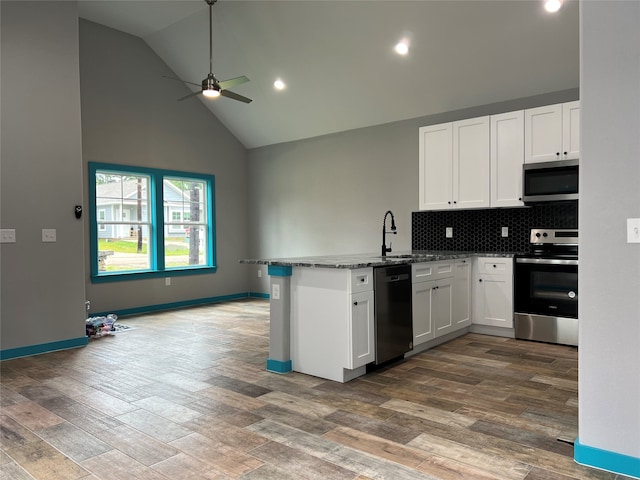 kitchen with stainless steel appliances, kitchen peninsula, high vaulted ceiling, wood-type flooring, and white cabinets