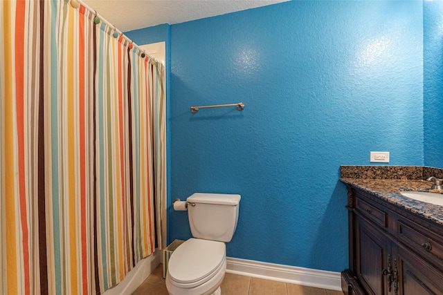 bathroom featuring toilet, tile patterned flooring, walk in shower, and vanity