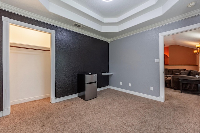 bedroom featuring crown molding, a raised ceiling, and stainless steel refrigerator