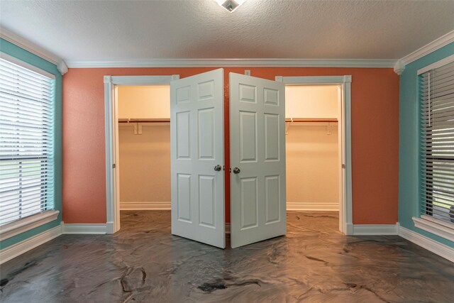 unfurnished bedroom featuring crown molding, a closet, and a walk in closet