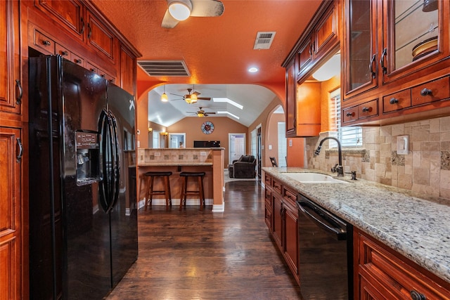 kitchen featuring ceiling fan, sink, black appliances, decorative backsplash, and lofted ceiling